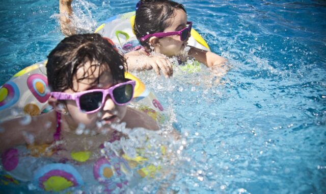 girls, swimming, splashing, sisters, little girls, floaters, swim, swimming pool, pool, summer, vacation, splashing water, childhood, children, kids, shades, sunglasses, people, water, cute, wet, young, happy, joy, nature, fun, activity, happiness